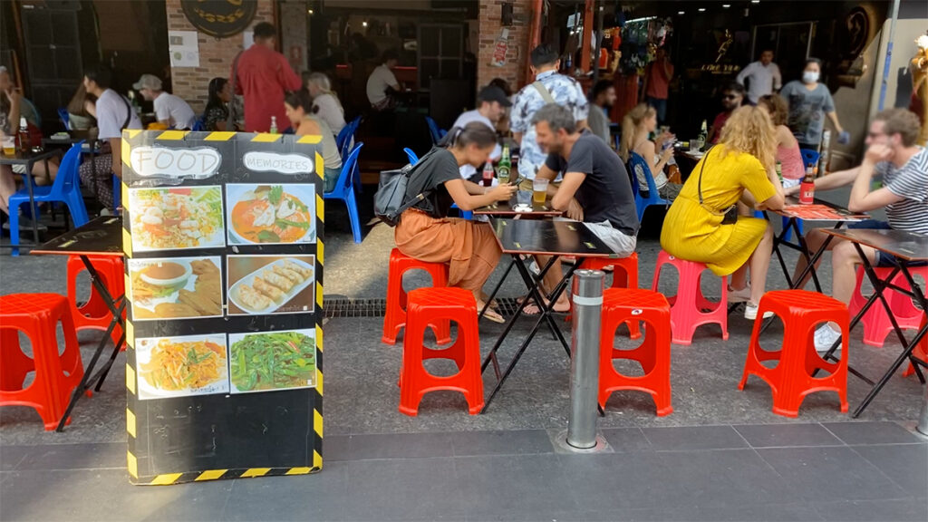 야외 테이블에서 식사하는 관광객들